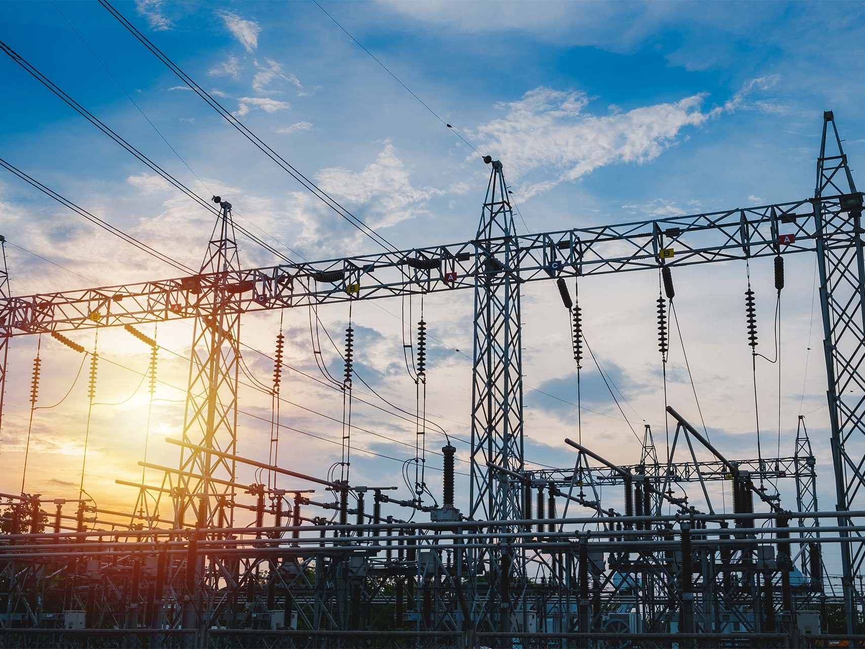 Sunset behind substation towers with blue sky